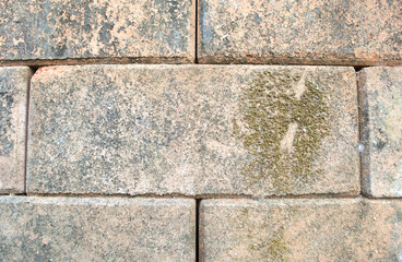 Part of an old and dirty  weathered brick wall in red and brown