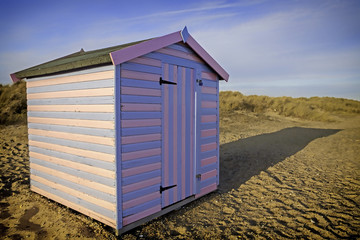 Naklejka premium Vibrant fun vacation beach hut. Picture taken just before sunset in the long-shadow sunlight.