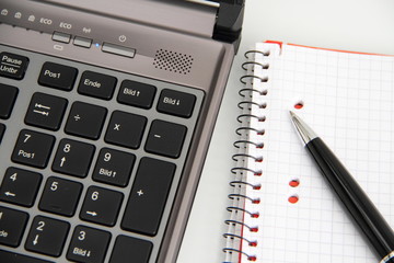 Laptop mit Stift und Block
