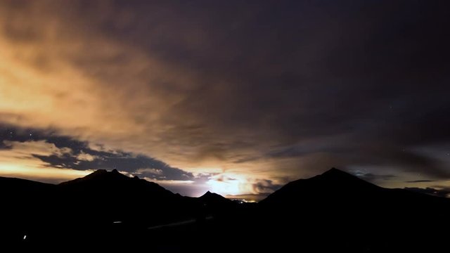 A 4k UHD time lapse shot of the milky way in the mountains with clouds and car traffic. 11319