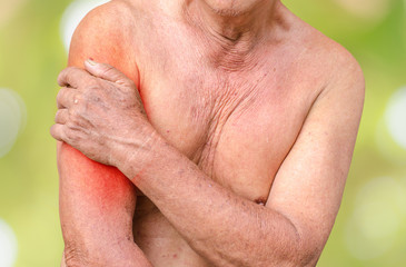 Senior man having shoulder pain,monochrome photo with red as a symbol for the hardening