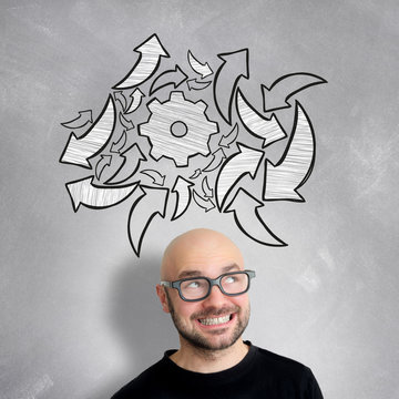 Young attractive smiling geek man with brainstormaing arrow over