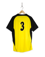 Yellow Football shirt hanging on hook and isolated on white