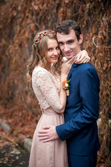 Naklejka premium Portrait of happy newlyweds in autumn nature. Happy bride and gr