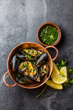 Mussels in copper bowl, lemon, herbs sauce and white wine.