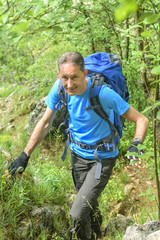 Mann beim Wandern auf einem Steig im Wald