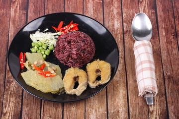 Brown jasmine rice topped green chicken curry and fish.