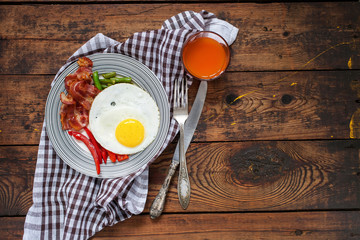 breakfast - fried eggs, siliculose haricot, bacon, a paprika and juice on a table, selective focus, top view, copy space