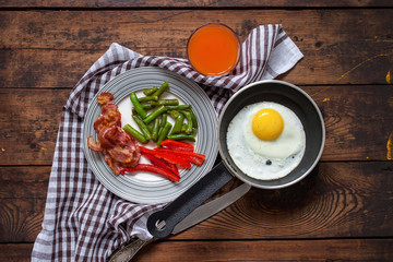 breakfast - fried eggs, siliculose haricot, bacon, a paprika and juice on a table, selective focus, top view, copy space
