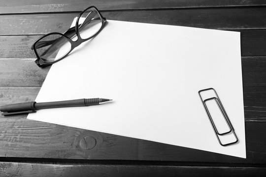 Blank notebook and pencil with glasses on wooden table