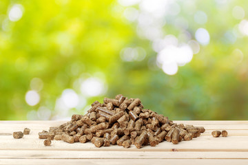 Wood pellets on a green background. Biofuels.