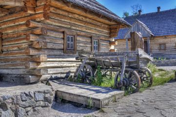 Obraz premium The old wooden house and a carriage in retro style