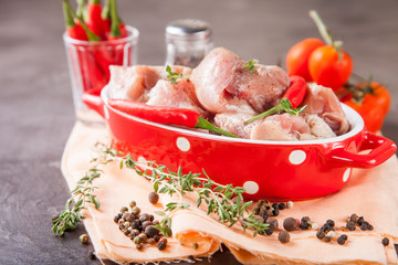 pieces of meat of chicken with tomatoes and pepper in a bowl on a table, selective focus, copy space