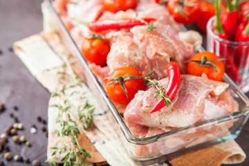 pieces of meat of chicken with tomatoes and pepper in a bowl on a table, selective focus, copy space