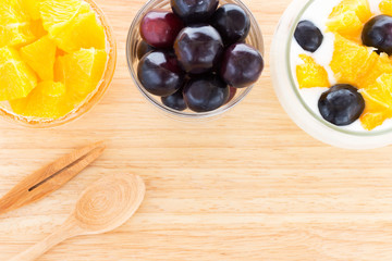 Fresh fruits with yogurt in a glass bowl on wood tray