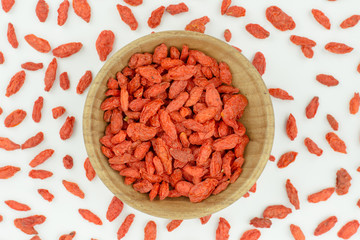 goji berries in wood bowl isolated on white background