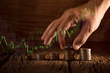 Double exposure of hand putting money coins stack in finance and banking concept.