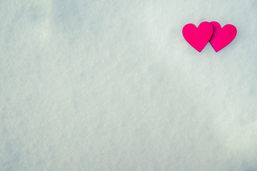Two red hearts lie on the snow 