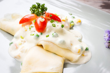 Crepes stuffed with cream cheese and chicken with white cream sauce