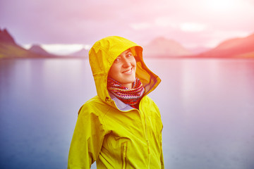 woman on the Lake coast with mountain reflection at the rainy day, Iceland