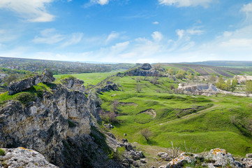 Fototapeta na wymiar Deposits of limestone, quarry, green hills and rural landscape
