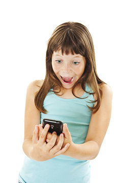 The young girl is holding a cell phone and looking at the screen with a surprised expression. Isolated on white background
