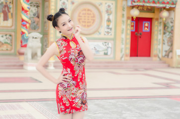 Beautiful  Asian girl wear cheongsam and show something to you in chinese new year