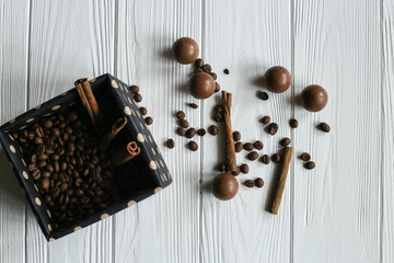 Set of coffee beans and chocolate sweets. White wooden background. Space for text