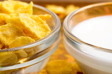 Dry corn flakes and milk in a transparent cups