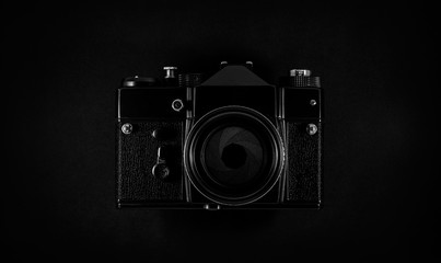 Old black SLR film camera with lens and aperture