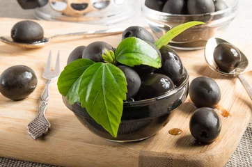 Foto op Plexiglas Black olives on a table and glass cups © romensky