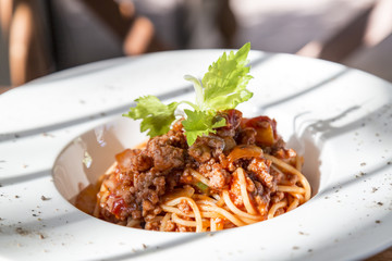 spaghetti tomato sauce with beef and pork in white deep plate