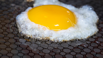 ein Spiegelei liegt in einer Pfanne und wird gebraten