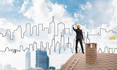 Man architect draw silhouette of modern city on blue sky. Mixed media