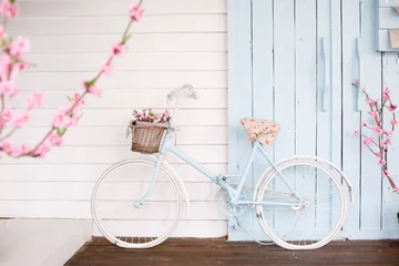 Rolgordijnen Witte fiets met mooie bloemenmand op vintage achtergrond. Lente en Pasen © Olga Mishyna