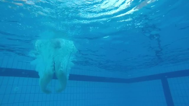 Shooting under water. The girl slowly sinks into the water in slow motion.
