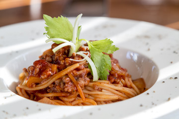 spaghetti tomato sauce with beef and pork in white deep plate