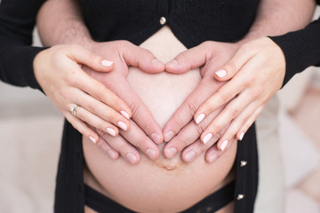Waiting for baby, mammy's and Dad's hands on a belly
