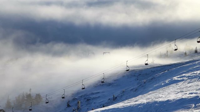 Winter mountains and ski lifts on a cloudy day