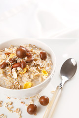 Healthy and natural breakfast, oatmeal and chocolate dragees in a bowl