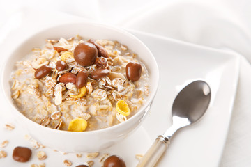 Healthy and natural breakfast, oatmeal and chocolate dragees in a bowl