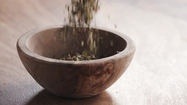 provence herbs falling in wood bowl on wooden table in slow motion, 180fps prores footage