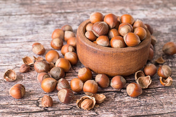  Nuts filbert.    Nuts filbert, whole and peeled, in a brown wooden bowl on old table.