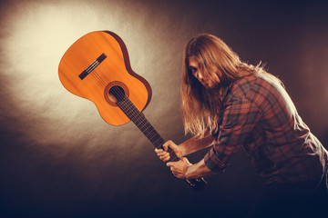 Rock musician destroys his guitar.