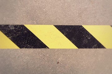 Attention. Warning tape yellow and black on a concrete floor. Danger. Caution.