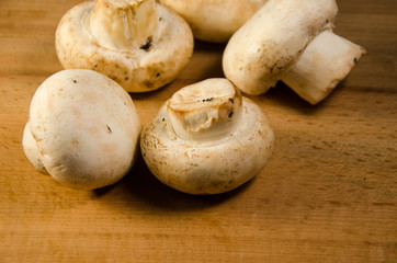White champignon mushrooms on a wooden table
