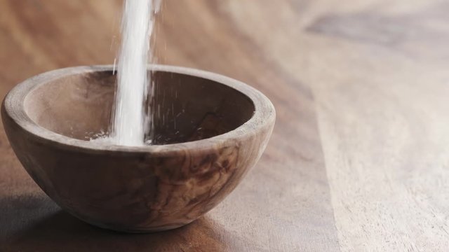 white sugar falling in wood bowl on wooden table in slow motion, 180fps prores footage