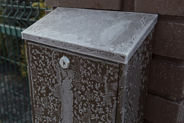 Frozen post box on the brick wall