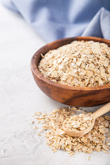 Oat flakes in a bowl on a table, selective focus, copy space