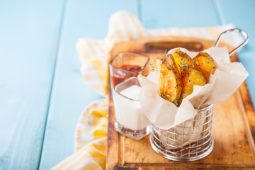 Roast potatoes in a bucket on a wooden background. Selective focus. Copy space.